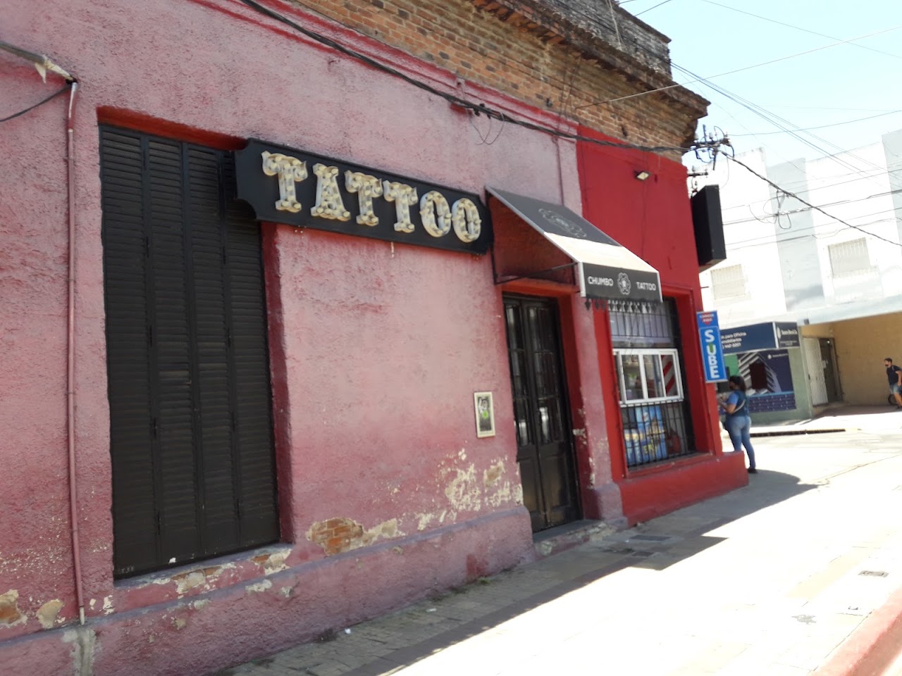 Fachada iluminada e interior boutique del estudio Chumbo Tattoo en Corrientes